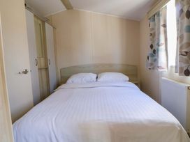 A bedroom with a bed and wardrobe at Dunes View in Prestatyn