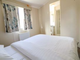 A bedroom with a bed and curtains at Dunes View in Prestatyn