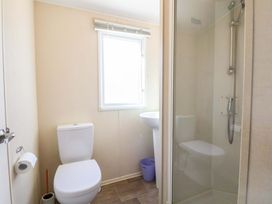 A bathroom with a toilet, shower and sink at Dunes View in Prestatyn