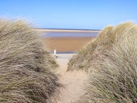 A path between grass leading to water at Dunes View in Prestatyn