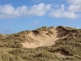 Sand dunes with grass under a blue sky at Dunes View in Prestatyn