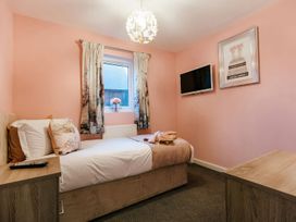 A bedroom with a bed and television at James Ville Marina Lodge 23 in Brigg