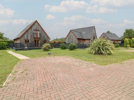 An outdoor area with multiple wooden houses and a paved path at James Ville Marina Lodge 10 in Brigg