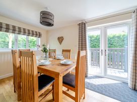 A dining room with a wooden table and chairs at James Ville Marina Lodge 10 in Brigg