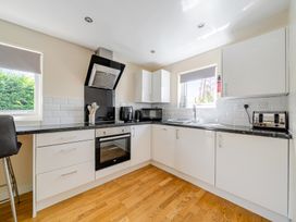 A kitchen with appliances and white cabinets at James Ville Marina Lodge 10 in Brigg