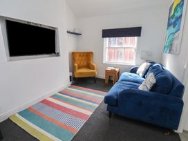 A living room with a blue sofa and yellow armchair at Apartment 3 in Scarborough