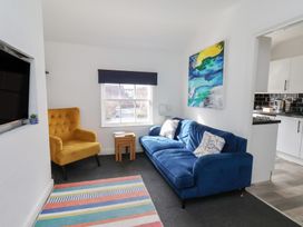 A living room with a blue sofa and yellow armchair at Apartment 3 in Scarborough