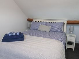 A bedroom with a bed, pillows, towels and a nightstand at Apartment 3 in Scarborough