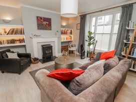 A living room with a fireplace and bookshelves at The Secret Garden in Narberth