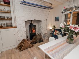 A dining room with a wood stove and table at The Secret Garden in Narberth