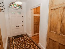 A hallway with a front door and stained glass window at The Secret Garden in Narberth