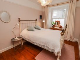 A bedroom with a bed and mirror at The Secret Garden in Narberth