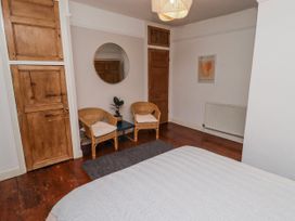 A bedroom with a wardrobe and two chairs at The Secret Garden in Narberth