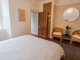 A bedroom with a bed and two armchairs at The Secret Garden in Narberth