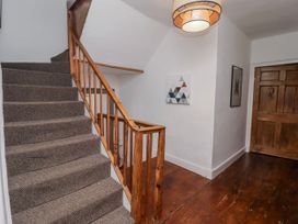 A staircase with wooden handrail in a hallway at The Secret Garden Narberth