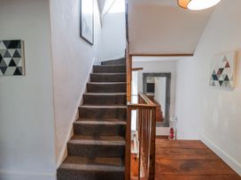 A hallway with stairs and a mirror at The Secret Garden in Narberth