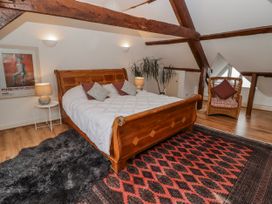 A bedroom with a wooden bed and decorative rug at The Secret Garden in Narberth