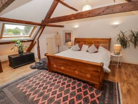 A bedroom with a wooden bed and a plant at The Secret Garden in Narberth