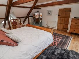 A bedroom with a bed and a chair at The Secret Garden in Narberth