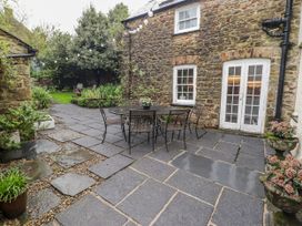 An outdoor space with a stone wall patio and table at The Secret Garden in Narberth
