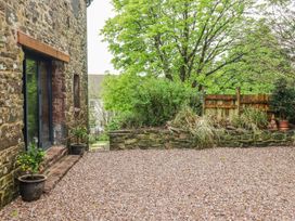 An outdoor space with gravel surface and stone wall at The Secret Garden in Narberth