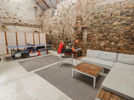 A game room with a ping pong table and sofa at The Secret Garden in Narberth