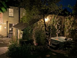 A garden with a hot tub and stone wall at The Secret Garden in Narberth