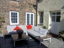 An outdoor patio with seating and a table at The Secret Garden in Narberth