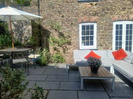 A garden area with a sofa, table, and chairs at The Secret Garden in Narberth