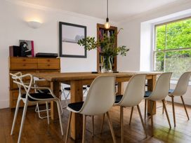 A dining room with a wooden table and chairs at The Secret Garden in Narberth