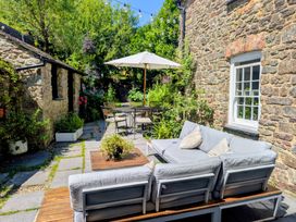 A garden with outdoor furniture and a stone pathway at The Secret Garden in Narberth