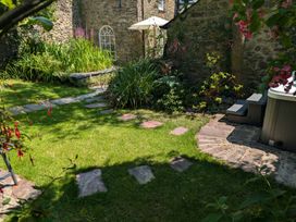 A garden with a pathway and hot tub at The Secret Garden in Narberth