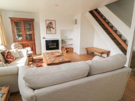 A living room with a sofa, coffee table, and bookshelf at 11 Berry Close in Painswick