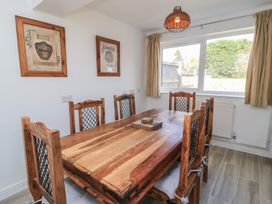 A dining room with a wooden table and chairs at 11 Berry Close in Painswick