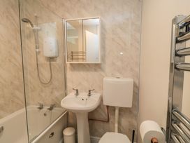 A bathroom with shower, sink, toilet and mirror at 11 Berry Close in Painswick