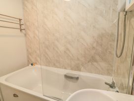 A bathtub with showerhead and rubber duck at 11 Berry Close Painswick