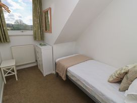 A bedroom with a bed and a chair at 11 Berry Close, Painswick