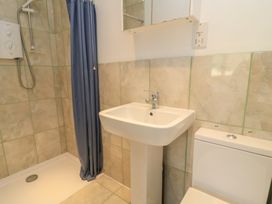 A bathroom with a shower, sink, and toilet at 11 Berry Close in Painswick