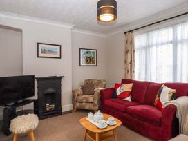A living room with a television and sofa at 16 Elmbank Gardens in Paignton