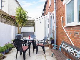 A garden with a table and chairs at 16 Elmbank Gardens Paignton