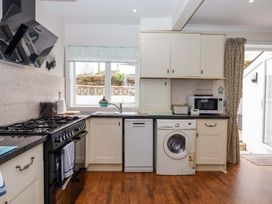 A kitchen with appliances including an oven and washing machine at 16 Elmbank Gardens Paignton