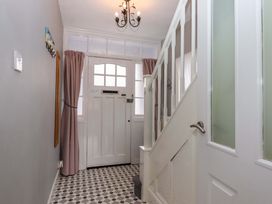 A hallway with a door and staircase at 16 Elmbank Gardens Paignton