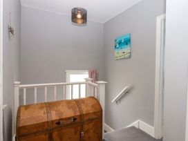 A hallway with a chest and a light fixture at 16 Elmbank Gardens Paignton