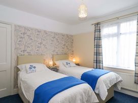 A bedroom with twin beds and a window at 16 Elmbank Gardens Paignton
