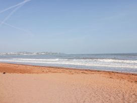 A beach with waves and sand at 16 Elmbank Gardens in Paignton
