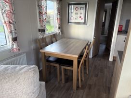 A dining room with a table and chairs at Harlyn Hideaway (Swift Barritz) Padstow