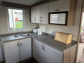 A kitchen with a sink and microwave at Harlyn Hideaway (Swift Barritz) Padstow