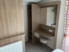 A bedroom with a dresser and mirror at Harlyn Hideaway (Swift Barritz) Padstow