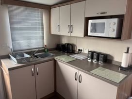 A kitchen with a microwave and sink at Harlyn Hideaway (Swift Barritz) Padstow