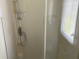 A shower with a showerhead and controls in a bathroom at Harlyn Hideaway (Swift Barritz) Padstow